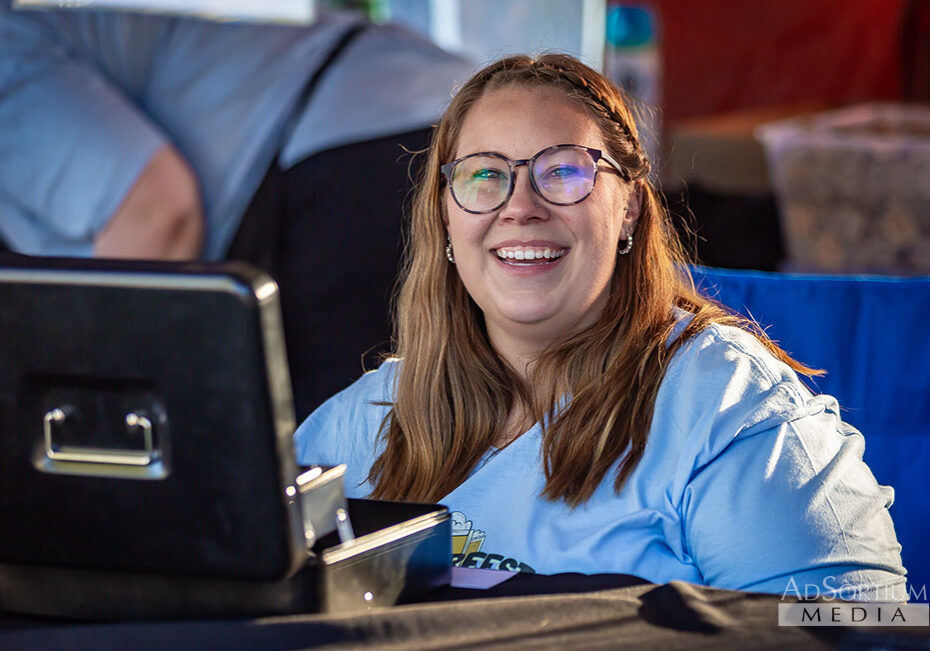 IMG_10792_CC_web Smiling Oktoberfest volunteer working at the registration booth.